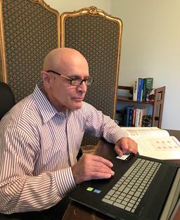 A man sitting at a desk with a laptop.