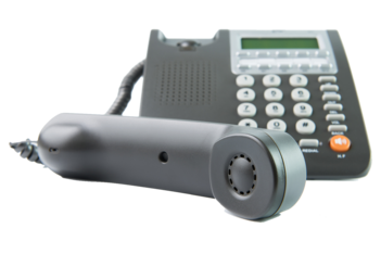 A telephone and a remote control on a green background